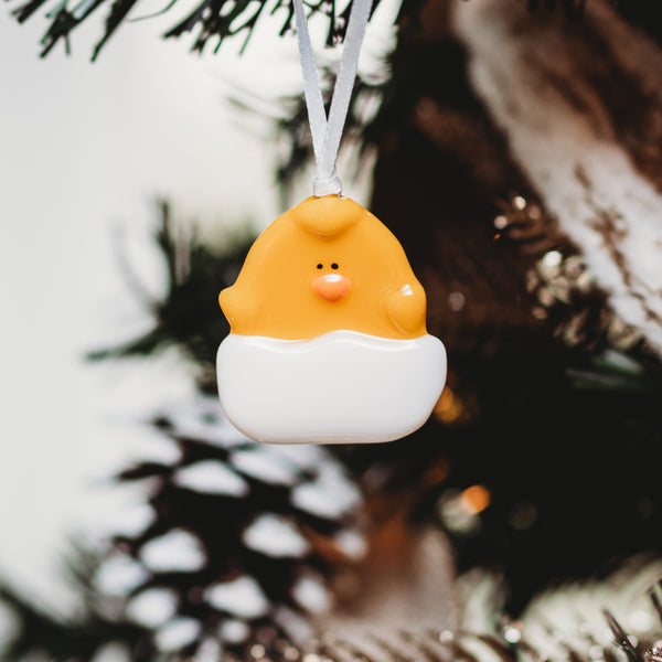 Poussin jaune dans sa coquille craquelée fait de verre. Élément décoratif pour Pâques et Noel